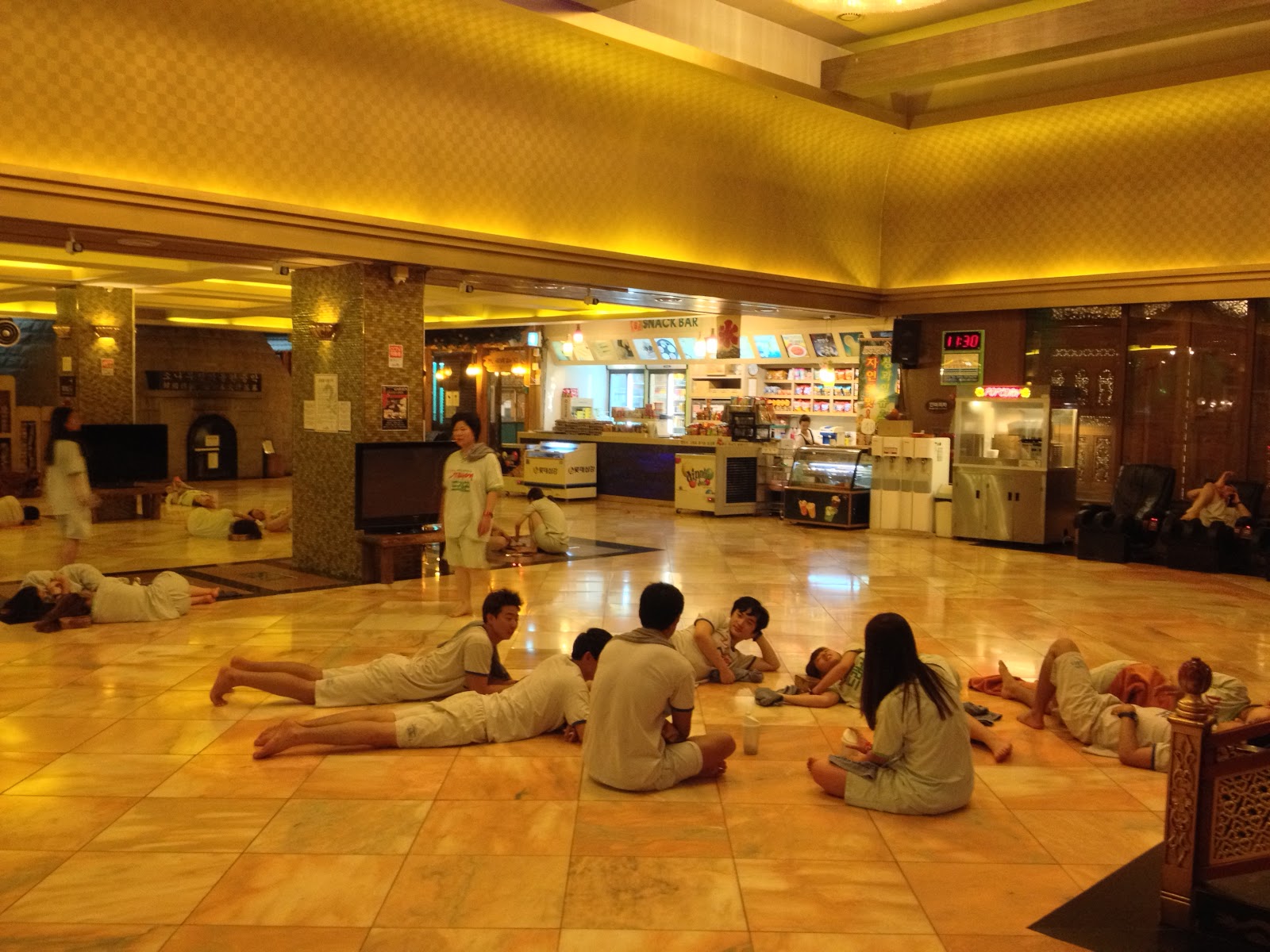 Relax at the spa center, wearing comfortable, lying on the floor, warm light, refreshment counter the far side.