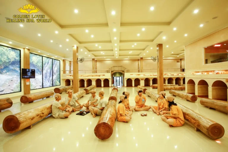 Nhóm người thư giãn trong phòng spa sang trọng với nội thất gỗ lớn tại Golden Lotus Healing Spa World.