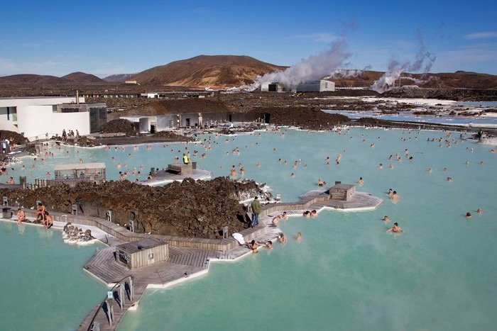 Khu ngâm nước nóng ngoài trời ở Iceland với khung cảnh thiên nhiên đẹp và mọi người đang thư giãn trong hồ nước.