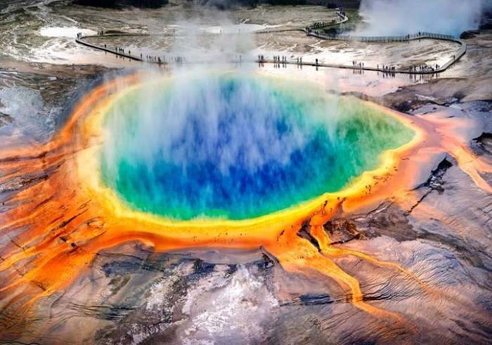 Hình ảnh suối nước nóng Grand Prismatic với sắc màu xanh, vàng, và cam nổi bật tại Yellowstone.